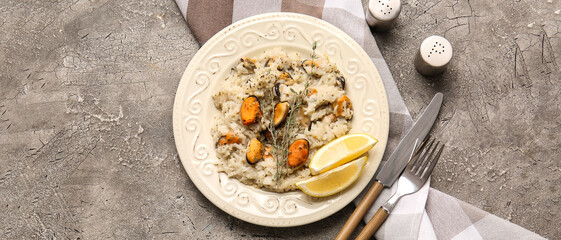 Plate with tasty seafood risotto on grunge background