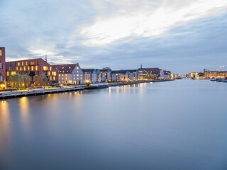 Buildings lit up on  Christianshavns canal after sunset, Copenhagen, Denmark