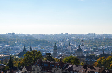 Fototapeta premium Panoramic view of old historical city center with churches, town hall and houses roofs at sunny autumn day. Lviv, Ukraine