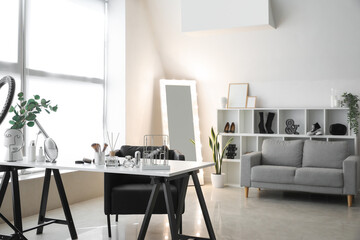 Interior of light makeup room with table, mirror and sofa