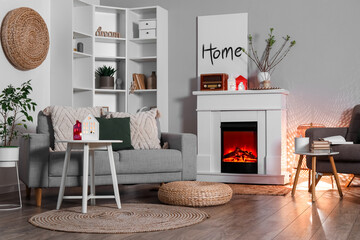 Interior of living room with fireplace, sofa and house candle holders