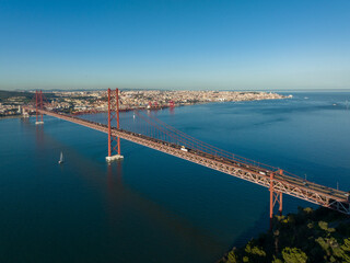 The 25 April bridge (Ponte 25 de Abril) located in Lisbon, Portugal, crossing the Targus river. Drone.