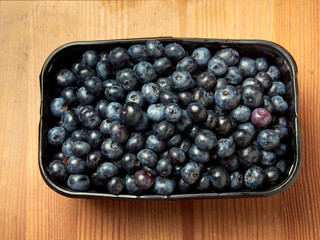 Freshly picked blueberries in a white vintage ceramic bowl. Selective focus, Free text space.