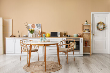 Interior of stylish kitchen with Easter decor, white counters and dining table