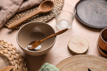 Beautiful table setting with plates, bowl and glass of water on beige grunge background