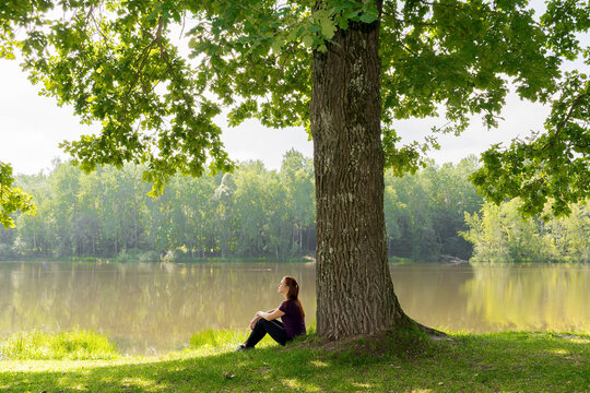 girl sitting against tree