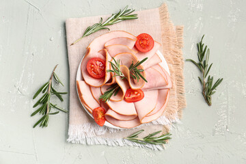 Plate with slices of tasty ham, tomatoes and rosemary on grey grunge background