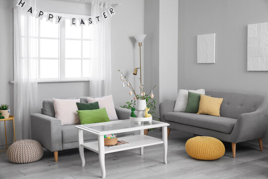 Interior of living room with Easter decor, table and sofas