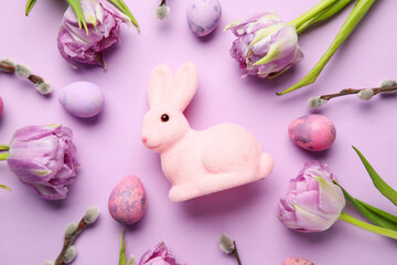 Composition with Easter bunny, tulip flowers, pussy willow branches and painted eggs on lilac background