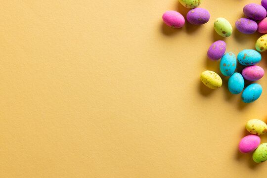 Image of multi coloured easter eggs with copy space on yellow background