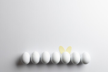 Obraz premium Image of row of white easter eggs with bunny ears and copy space on white background