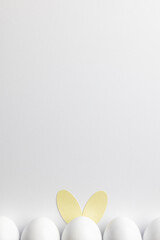 Image of row of white easter eggs with bunny ears and copy space on white background