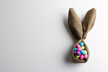 Image of multi coloured easter eggs and bunny ears with copy space on white background