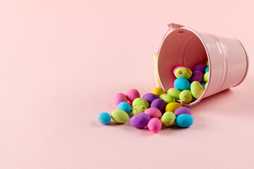 Image of multi coloured easter eggs and pink bucket with copy space on pink background © vectorfusionart
