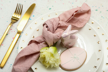 Table setting with Easter egg, bunny and tulip flower on white background