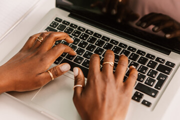 Cropped image african american woman hands hipster sitting outside street cafe with laptop, working...