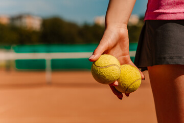 Caucasian woman hold yellow green balls, playing tennis match on clay court surface on weekend free time sunny day. Female player ready to serve, wear skort. Professional sport concept
 - obrazy, fototapety, plakaty