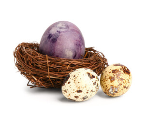 Nest with painted Easter and quail eggs isolated on white background