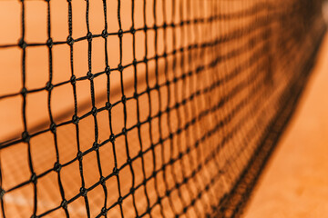 Light orange empty outdoor clay court surface dry grungy ground baseline detail for playing tennis with net in sunny day, gravel texture background, copy space for text inscription banner
 - obrazy, fototapety, plakaty