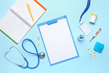 Blank clipboard and notebook with medical supplies on blue background. World Health Day