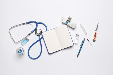 Blank notebook with medical supplies on white background. World Health Day - obrazy, fototapety, plakaty