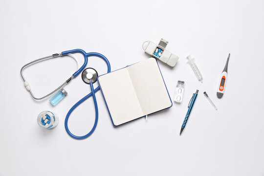 Blank notebook with medical supplies on white background. World Health Day