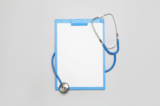 Blank clipboard with stethoscope on grey background. World Health Day - Powered by Adobe