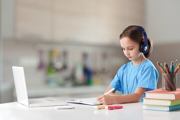 Focused child with a laptop study at home