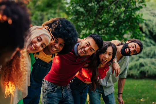 Cheerful friends in group huddle outdoors