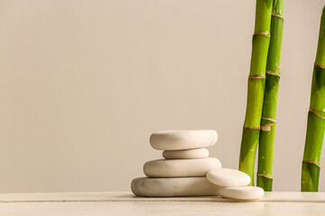 Fototapeta na wymiar Stack of spa stones and bamboo on light background