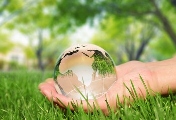 Glass globe in human hand. Ecology concept.