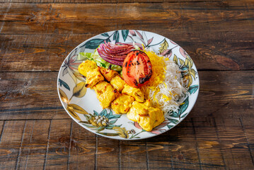 A plate of chicken skewers cooked on the grill in the middle eastern style accompanied by grilled vegetables and rice with sauce