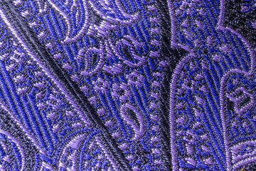Macro purple, blue and black stitching on a silk necktie