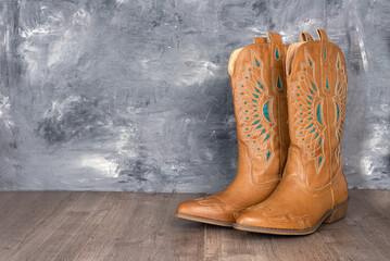 Cowboy boots  against a gray wall. Adventure and travel concept.