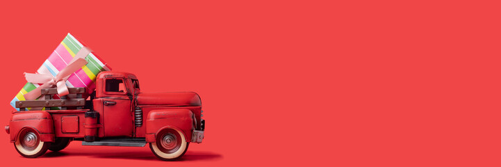 red tractor carries boxes with gifts on a red background. Banner, space for text.