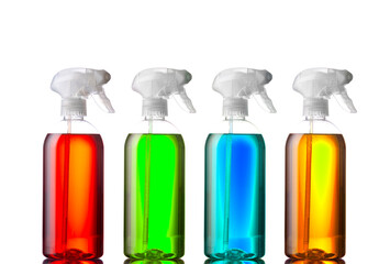 Group of colorful spray bottles with fluid in them.