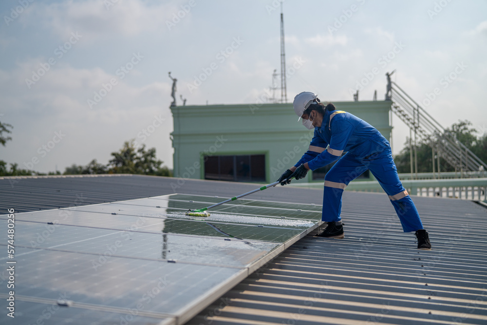 Poster man using a mop and water to clean the solar panels that are dirty with dust and birds' droppings to