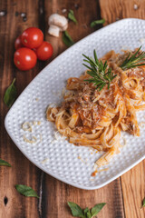 Comida italiana, plato pasta con salsa en la mesa de un restaurante típico de Italia.