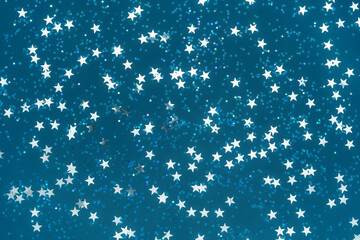 Abstract trendy holiday background with star shaped confetti toned in trendy dark teal color. Greeting card. Banner design. Copy space.