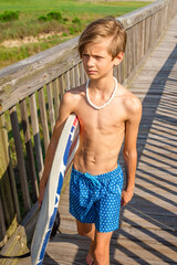 Youth Child Preteen Boy Walking on Boardwalk in Swim Trunks with Boogie Board