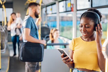 African american woman riding in a bus and using a smartphone