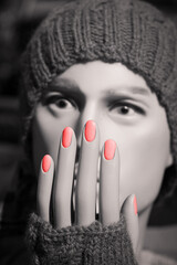 Black and white photo of a manikin head with red fingernail polish