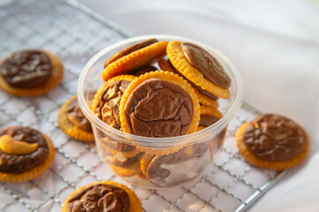 High angle view a cup of cracker with brownies  a cooling rack on a white table.