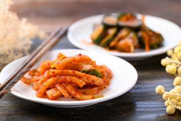 Kimchi radish and cucumber on wooden background, Korean food homemade side dish