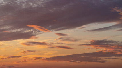 Sunset sky. Cirrocumulus and cirrostratus clouds during sunset. Beautiful dramatic sunset sky background. Selective focus included. Noisy photo.