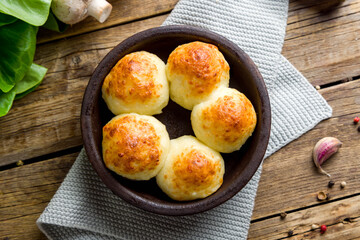 mushrooms baked with Suluguni cheese on old wooden table top view