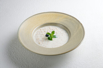 oatmeal porridge with blueberry and mint on white table