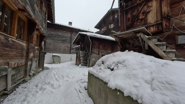 A farm in winter with snow. Barriers for animals and stables in an old settlement
