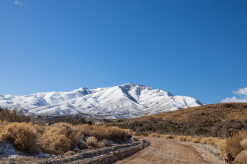 Dirt road and snow covered mountains at Spring Mountain National Recreation Area, Nevada