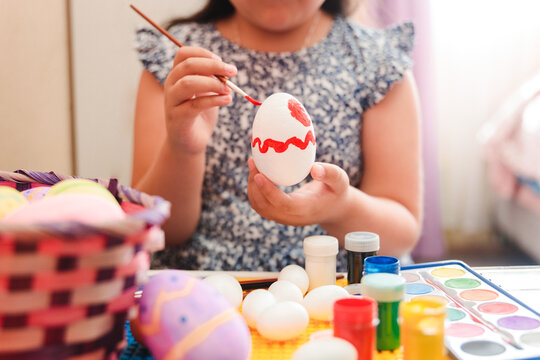Close up of an unrecognizable cute latin girl painting easter eggs in her bedroom.